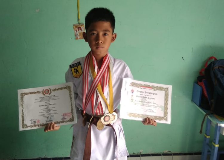 Atlet muda berpeatasi asal Kabupaten Pelabuhan Belawan, Satrio Bayu Pratama saat menunjukan medali dan piagamnya. Foto: Rj. Samosir/TNC.
