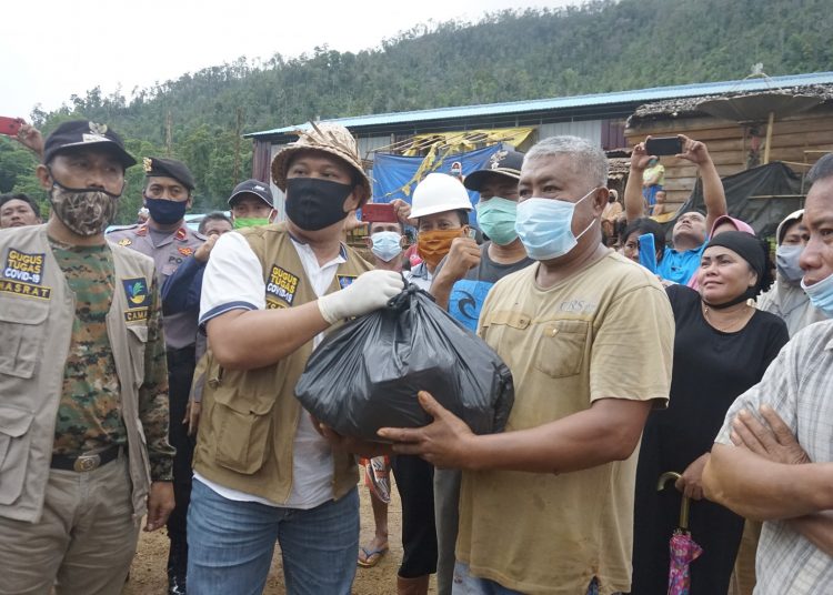 Bupati Konawe Utara, Ruksamin, serahkan bantuan kepada warga yang terdampak banjir. Foto Kominfo Konawe Utara.