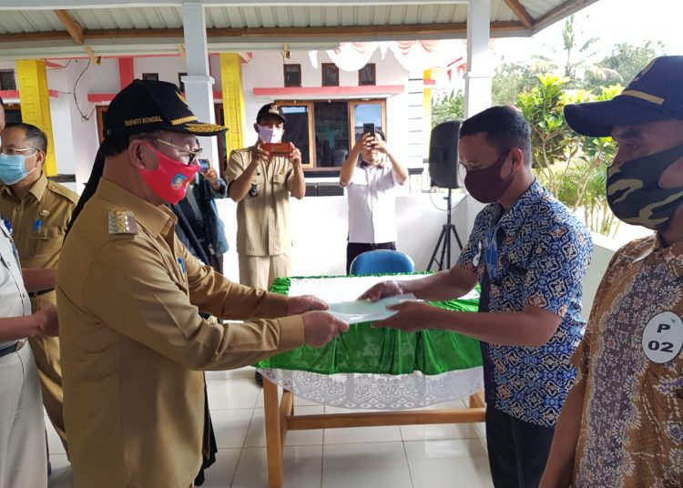 Bupati Konawe Selatan, Surunuddin Dangga secara simbolis menyerahkan sertifikat tanah kepada warga Mowila.