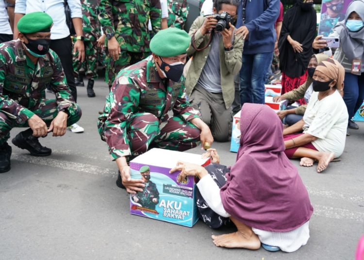 Mayjen TNI (Purn) Andi Sumangerukka duduk memberikan bantuan Sembako kepada warga.