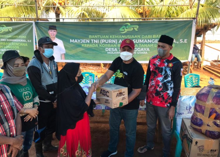 Relawan Andi Sumangerukka menyerahkan bantuan kemanusiaan korban longsor di Desa Tapunggaya, Konawe Utara