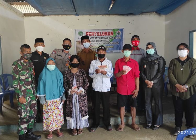 Kepala Desa Hudoa menyerahkan BLT danda desa kepada warga.