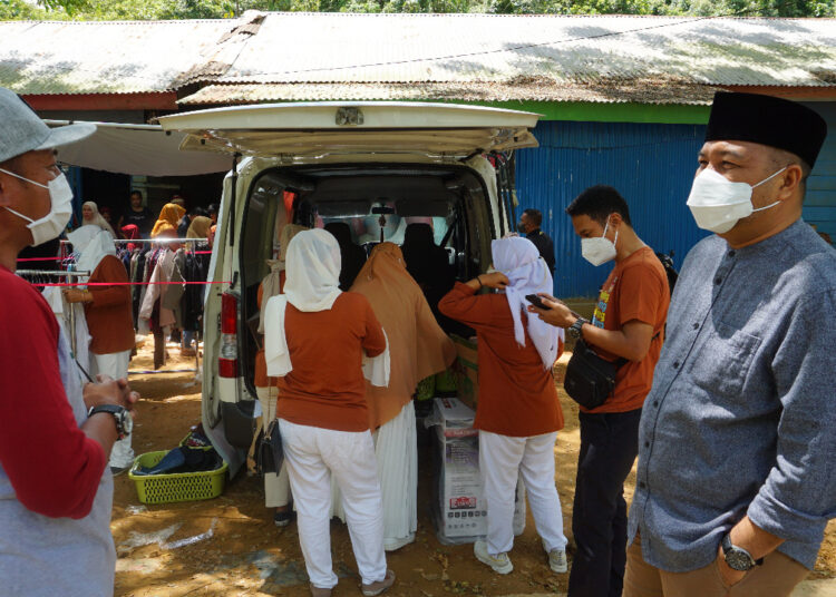 Aksan Jaya Putra (kanan) bersama alumnis SMANSA membagikan pakaian gratis kepada warga yang tinggal di TPA Puwatu.